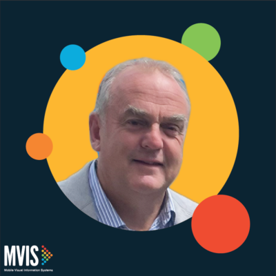 An Image of CEO, Pat Musgrave, in a yellow dot on a navy background. the MVIS logo in the bottom let corner.